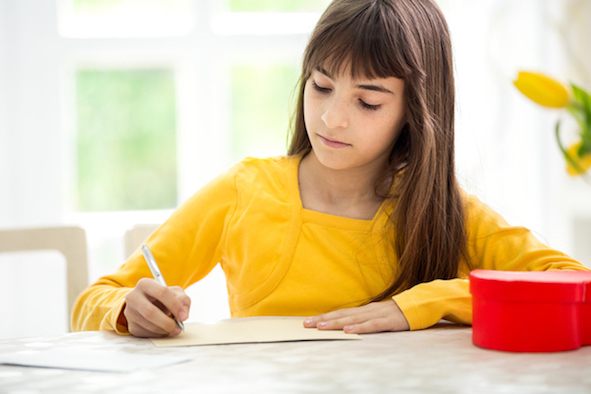 adorable girl writing greeting card
